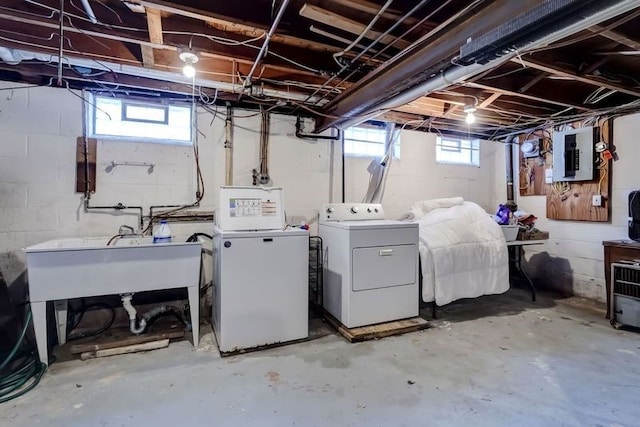 clothes washing area with a wealth of natural light, electric panel, and washer and dryer