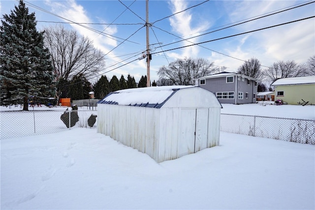 yard covered in snow with a storage shed