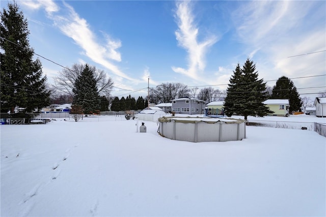 snowy yard featuring a covered pool