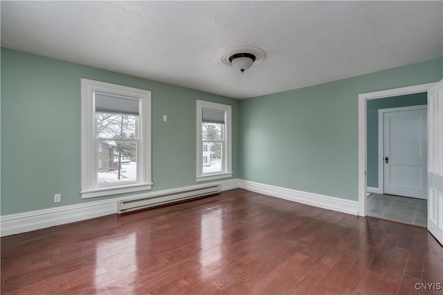 spare room featuring hardwood / wood-style flooring and baseboard heating