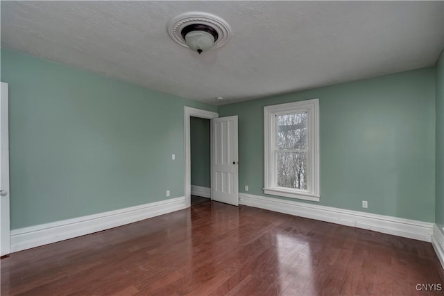 unfurnished room with dark hardwood / wood-style floors and a textured ceiling