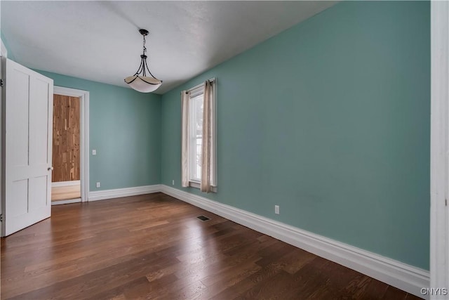 spare room featuring dark wood-type flooring