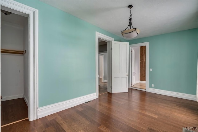 unfurnished bedroom featuring dark hardwood / wood-style floors and a closet