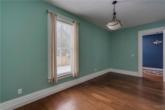 unfurnished dining area with hardwood / wood-style flooring and an inviting chandelier