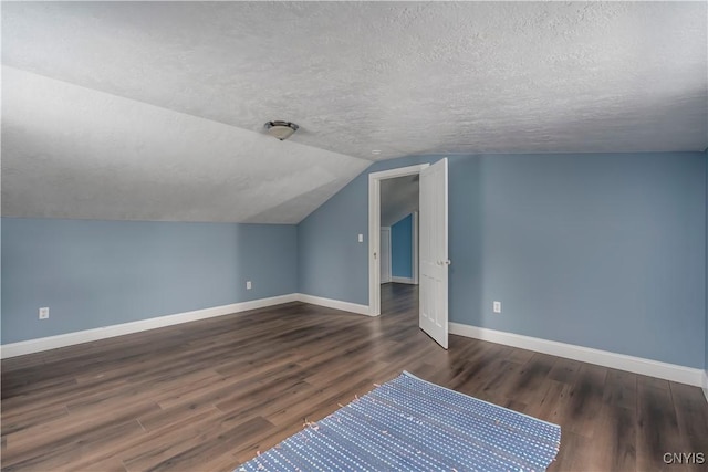 bonus room featuring vaulted ceiling, dark hardwood / wood-style floors, and a textured ceiling