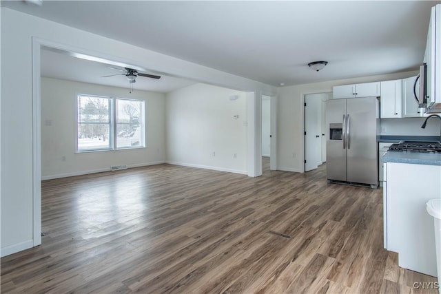 kitchen featuring appliances with stainless steel finishes, dark wood-type flooring, white cabinets, and ceiling fan