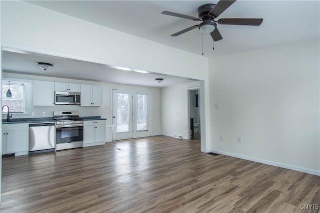 kitchen with sink, dark wood-type flooring, white cabinets, and appliances with stainless steel finishes