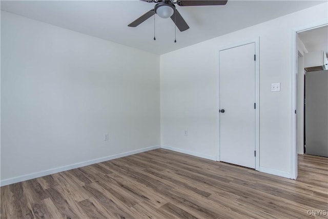 unfurnished bedroom featuring ceiling fan, stainless steel fridge, and light hardwood / wood-style flooring