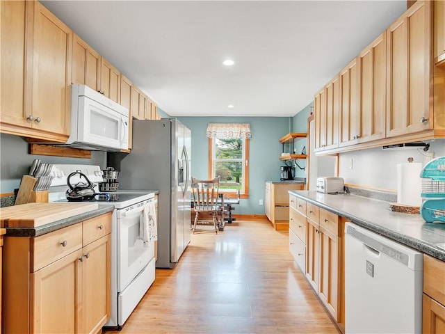 kitchen with light brown cabinetry, white appliances, and light hardwood / wood-style floors