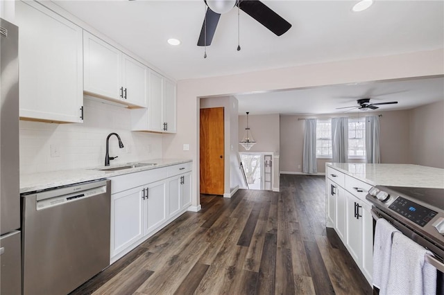 kitchen featuring white cabinetry, appliances with stainless steel finishes, sink, and light stone counters