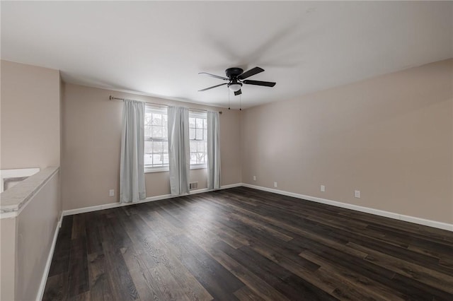 empty room with ceiling fan and dark hardwood / wood-style flooring