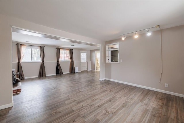 empty room with track lighting and light wood-type flooring