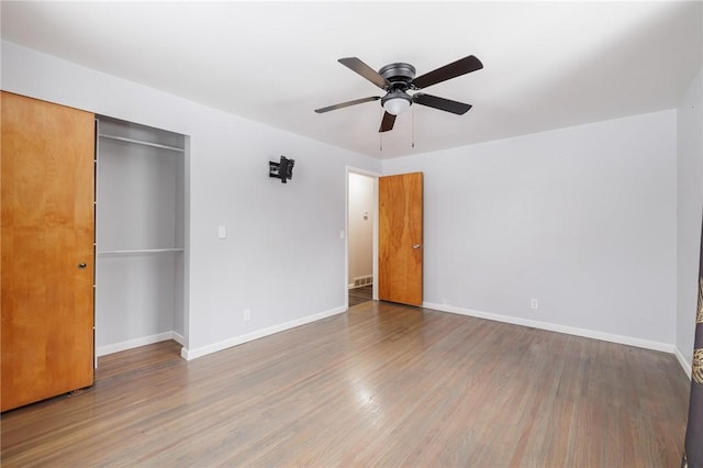 unfurnished bedroom featuring hardwood / wood-style flooring, a closet, and ceiling fan