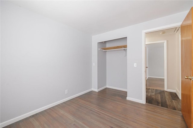 unfurnished bedroom featuring dark hardwood / wood-style flooring and a closet