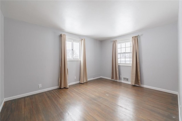 spare room featuring a healthy amount of sunlight and hardwood / wood-style floors