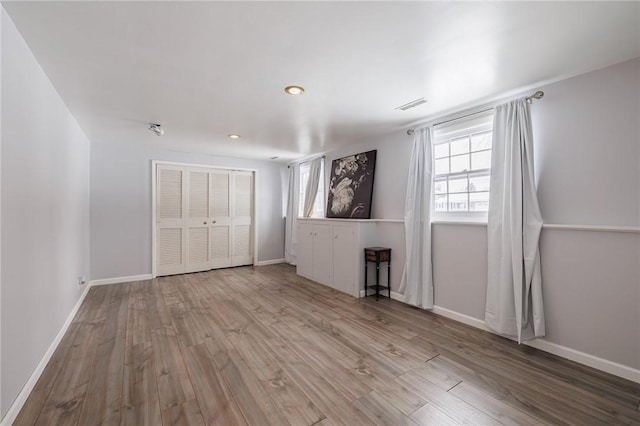 unfurnished bedroom with a closet and light hardwood / wood-style flooring