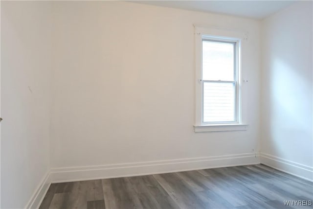 spare room featuring dark wood-type flooring and a healthy amount of sunlight