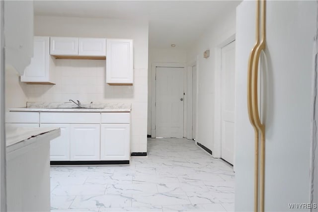 kitchen featuring white cabinetry, tasteful backsplash, sink, and white fridge