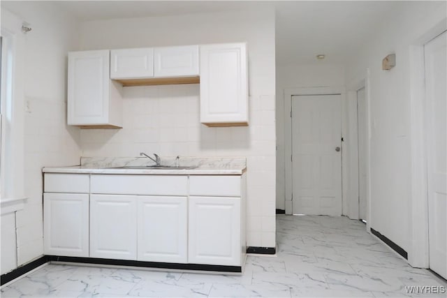 kitchen featuring sink and white cabinets