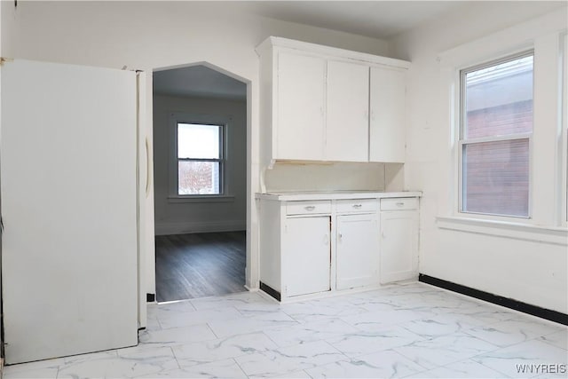 kitchen with white cabinetry and white fridge