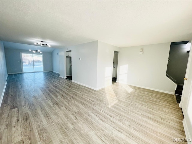 unfurnished living room featuring a textured ceiling and light wood-type flooring