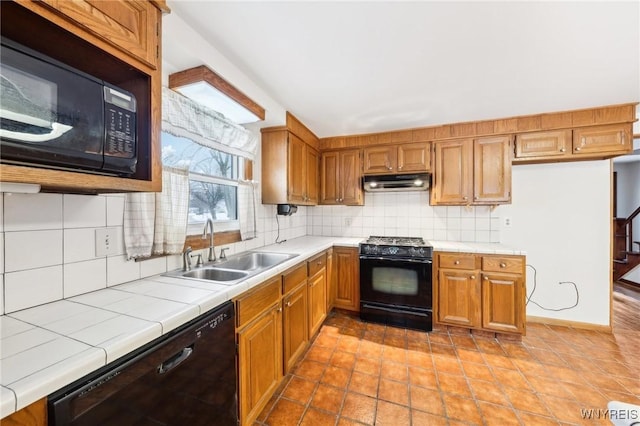 kitchen featuring tile countertops, sink, backsplash, light tile patterned floors, and black appliances