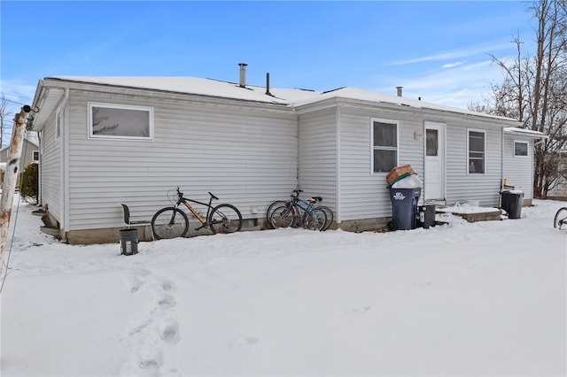 view of snow covered back of property