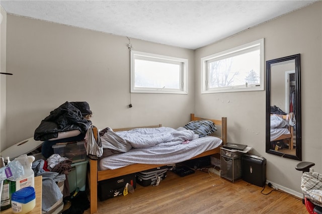 bedroom with hardwood / wood-style flooring and a textured ceiling