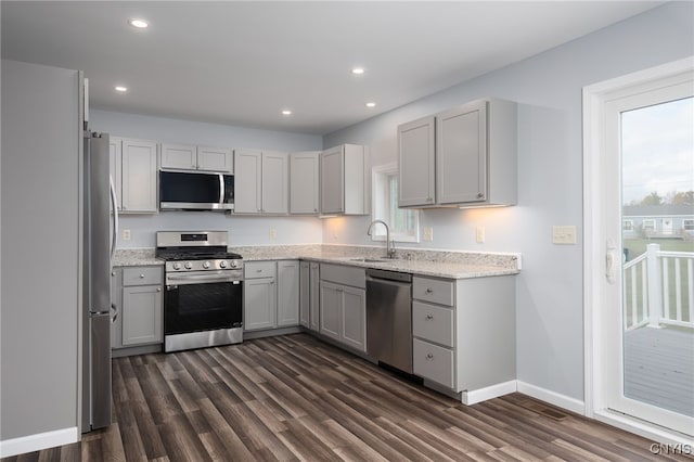 kitchen with dark wood-type flooring, appliances with stainless steel finishes, gray cabinets, and sink