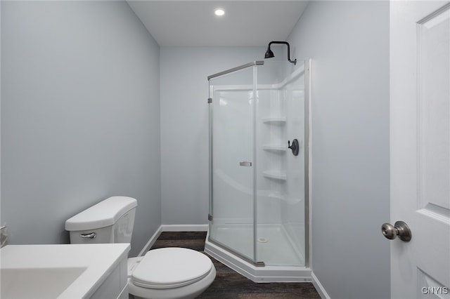 bathroom with vanity, toilet, a shower with door, and hardwood / wood-style floors