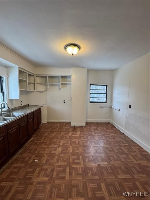 clothes washing area featuring dark parquet flooring and sink