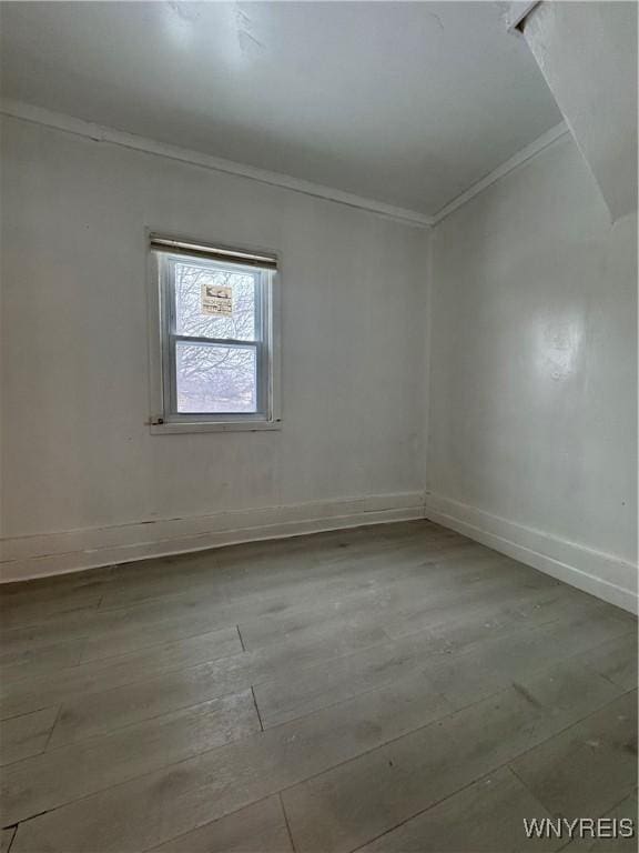 empty room with ornamental molding and light hardwood / wood-style floors