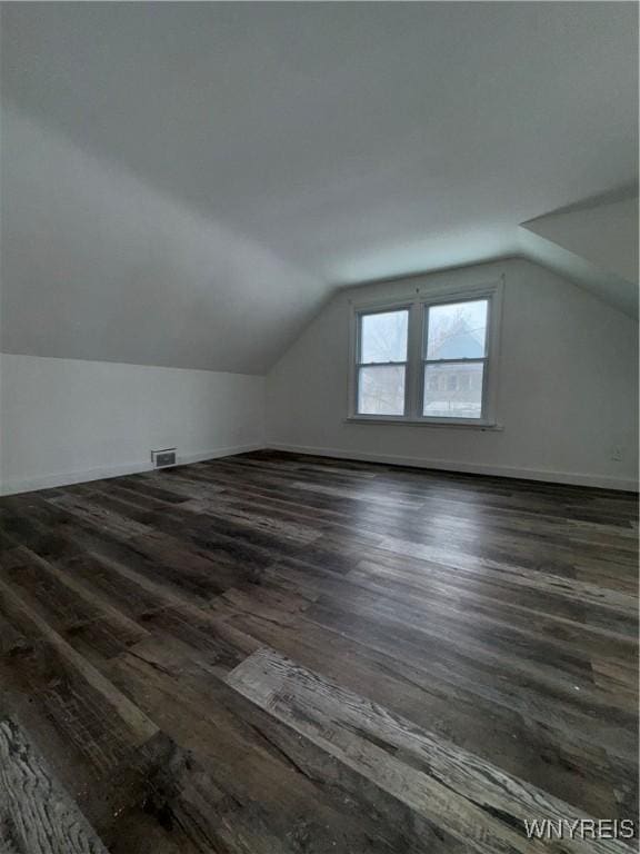 bonus room with lofted ceiling and dark hardwood / wood-style floors