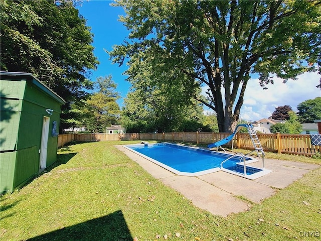 view of swimming pool with a patio area, a lawn, and a water slide