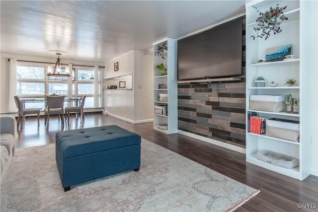 living room with an inviting chandelier, hardwood / wood-style floors, and built in features