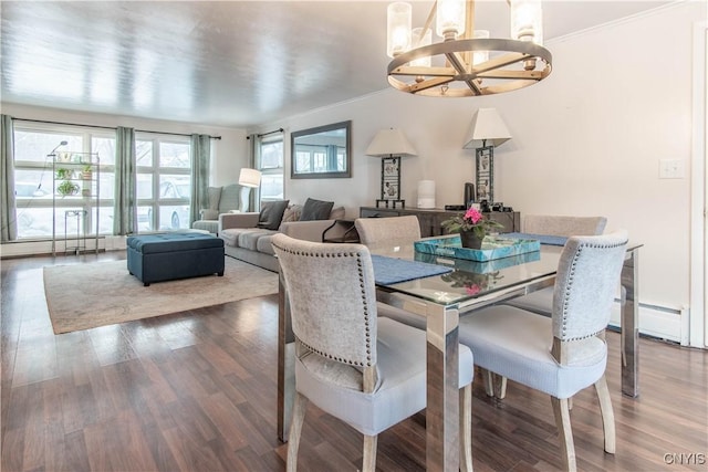 dining space with ornamental molding, hardwood / wood-style floors, and a chandelier