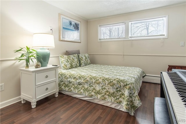 bedroom with dark wood-type flooring, a textured ceiling, and a baseboard heating unit