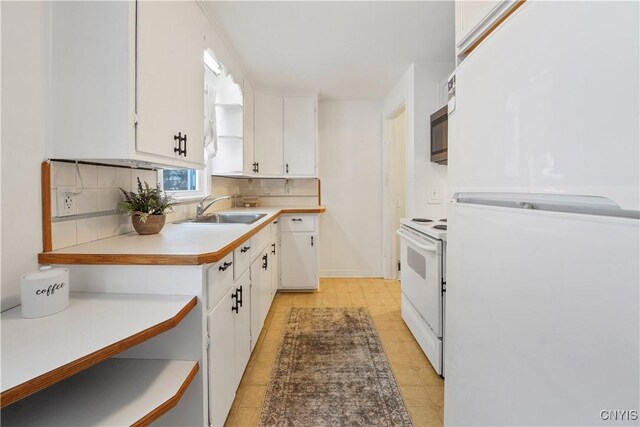 kitchen with backsplash, white appliances, sink, and white cabinets