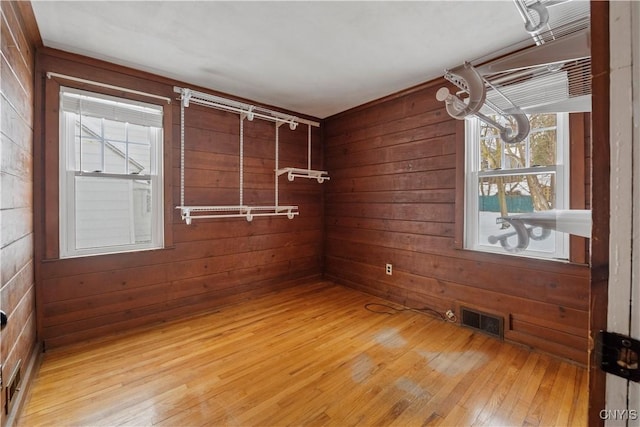 empty room featuring hardwood / wood-style floors and wooden walls