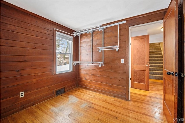 empty room with wooden walls and light wood-type flooring