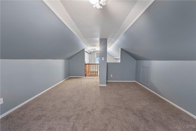 additional living space with vaulted ceiling and light carpet