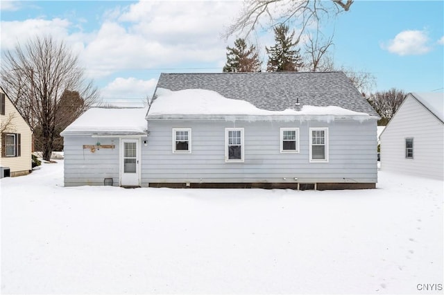 view of snow covered back of property