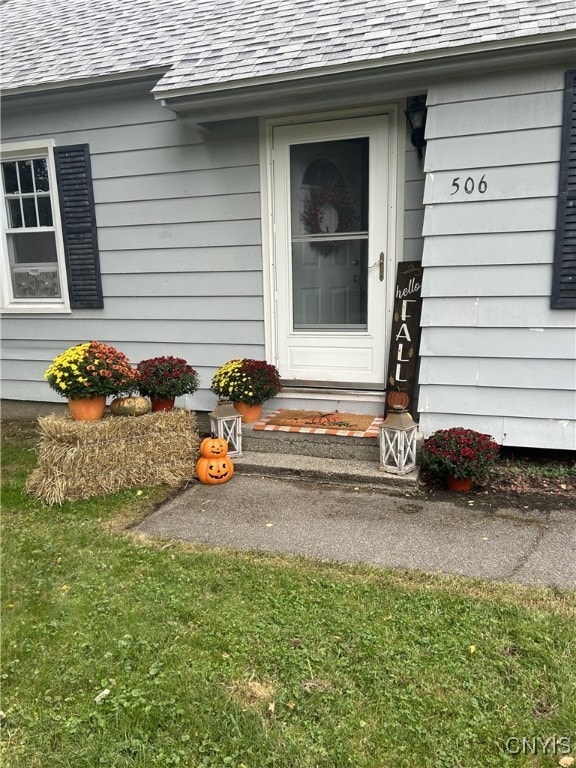 doorway to property with a lawn