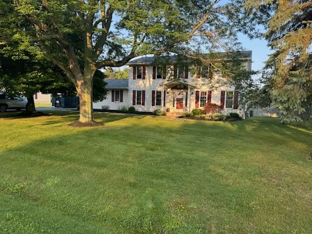 colonial-style house featuring a front lawn