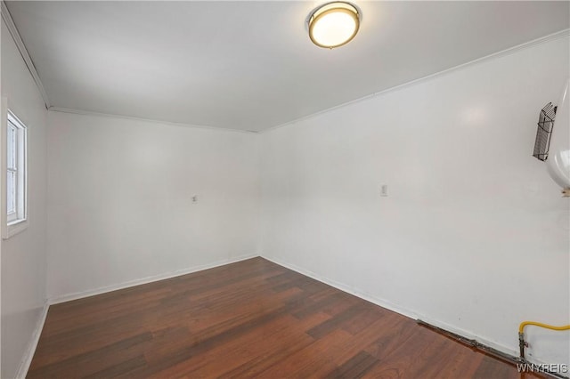 empty room featuring crown molding and dark hardwood / wood-style flooring