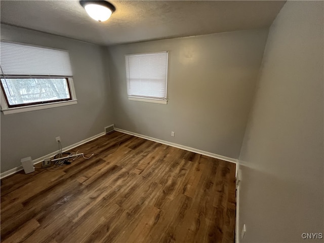 spare room with dark wood-type flooring