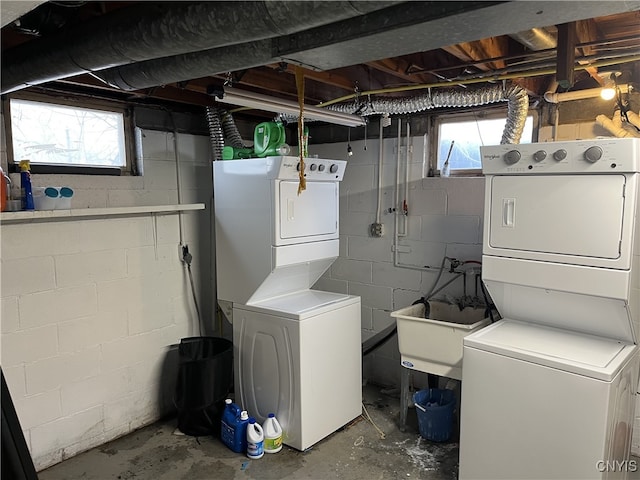 laundry area featuring a wealth of natural light and stacked washer and clothes dryer