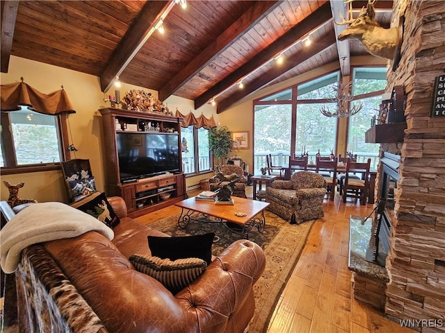 living room featuring light wood-type flooring, wooden ceiling, a healthy amount of sunlight, and vaulted ceiling with beams