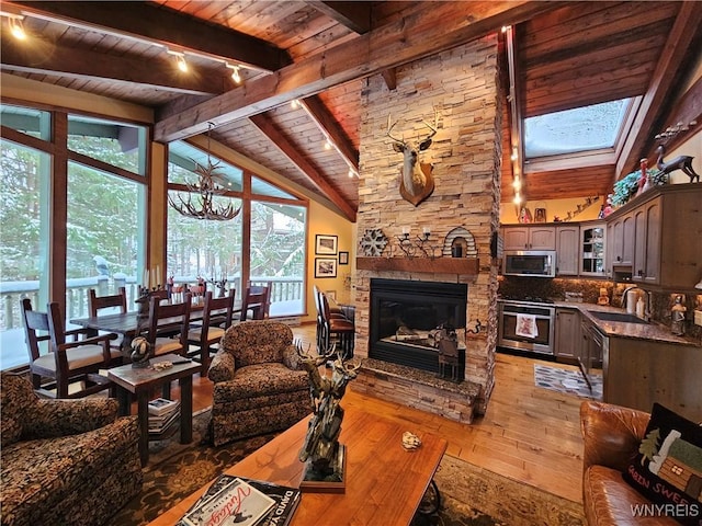 living room featuring light wood-style floors, wood ceiling, a fireplace, and lofted ceiling with skylight