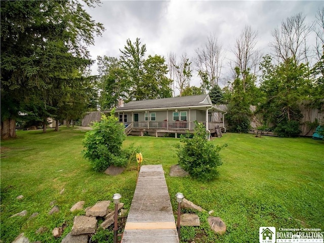 back of house featuring a wooden deck and a lawn